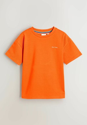 Krátky rukáv, oranžové bavlnené tričko s okrúhlym výstrihom a malým bielym logom na ľavej hrudi. Hladká textúra a uvoľnený strih.