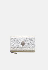 Borsa a pochette glitterata argento con una chiusura a forma di conchiglia testurizzata, design rettangolare e tracolla rimovibile.