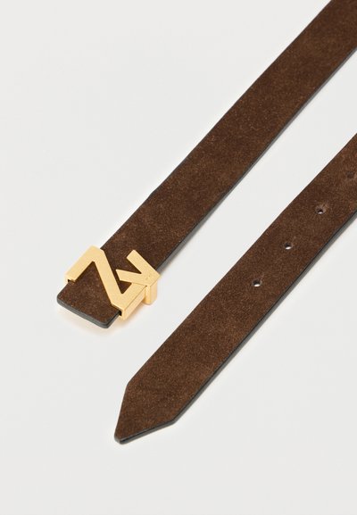 Καφέ ζωνάρι από σουέντ με επίπεδο σχέδιο, διακοσμημένο με χρυσή γεωμετρική αγκράφα. Το λουρί έχει τρύπες για ρύθμιση μεγέθους και μυτερή άκρη.