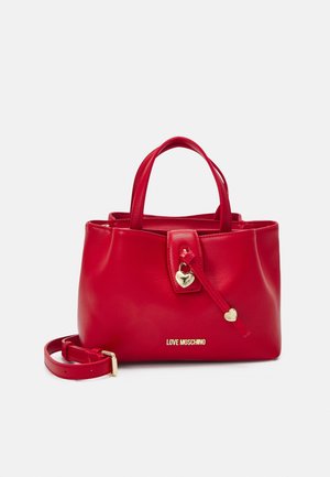 Czerwona syntetyczna torebka o gładkiej fakturze, z pozłacaną zawieszką w kształcie serca i logo u podstawy. Posiada dwie górne rączki oraz odpinany pasek.