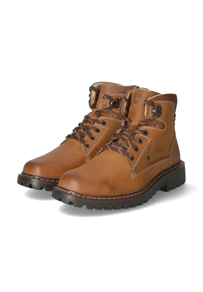 Botas de cuero marrón hasta el tobillo con cordones oscuros, cuello acolchado y una suela robusta. Presentan detalles de costura y una marca en el lateral.