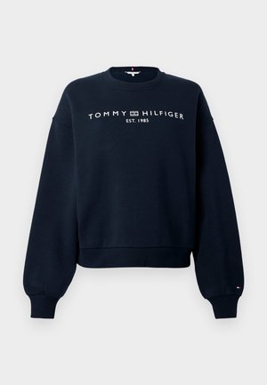 Tumesinist pusatreeningut ümarate kaeluse, pikkade varrukate, soonikulisade ja alläärega. Ees valge "TOMMY HILFIGER" logo ja asutamisaasta.