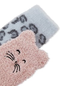 Dos pares de calcetines: uno rosa, que asemeja la cara de un gato con una textura suave, y otro gris claro con un patrón de manchas de leopardo negro.