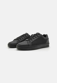 Black lace-up sneakers with smooth leather and textile panels, rubber outsole, round toe, and subtle branding on heel.
