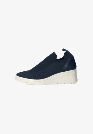 Sneaker slip-on blu navy con tomaia in maglia, linguetta per il tiraggio e suola platform bianca spessa inclinata per uso casual.