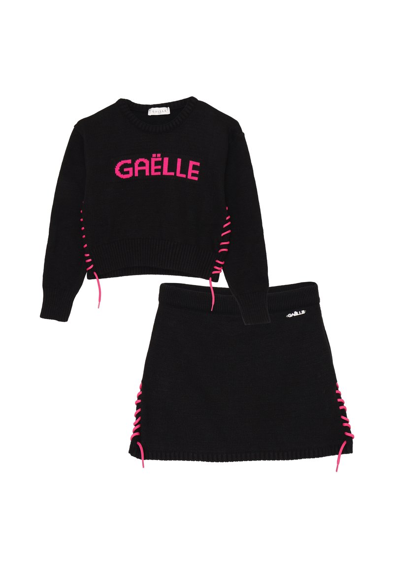 Set di maglione e gonna nera lavorata a maglia con testo rosa "GAËLLE". Il maglione presenta un laccio rosa laterale; la gonna ha un dettaglio di laccio coordinato.