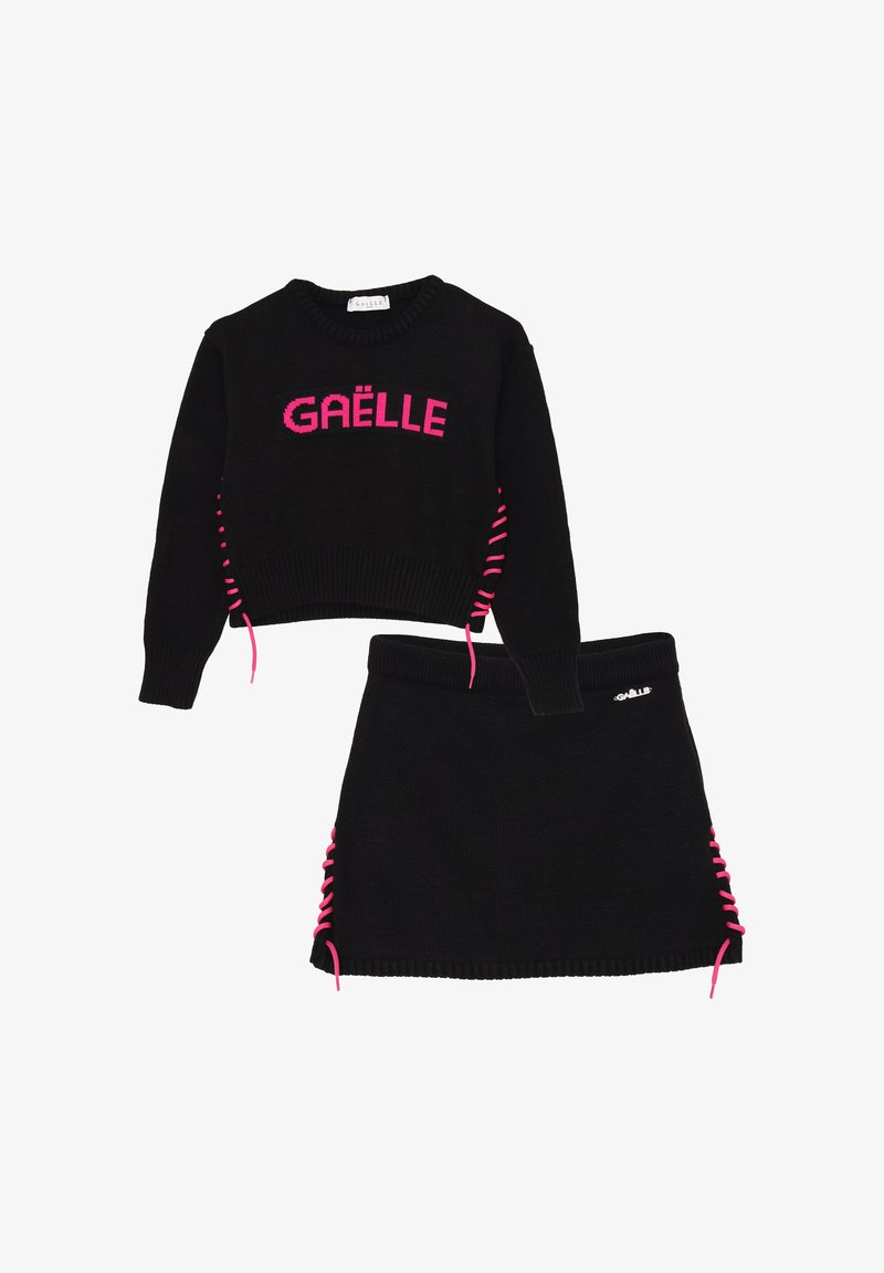 Set di maglione e gonna nera lavorata a maglia con testo rosa "GAËLLE". Il maglione presenta un laccio rosa laterale; la gonna ha un dettaglio di laccio coordinato.