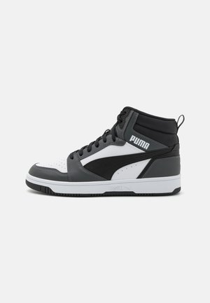 Basket montante Puma blanche, noire et grise avec le logo Puma sur le côté et fermeture à lacets, présentée de profil sur un fond clair.