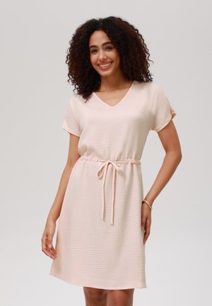 Short-sleeved, V-neck dress in soft pink fabric with a textured finish, cinched at the waist with a drawstring tie.