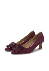 Purple suede high heels with a pointed toe, featuring a decorative rhinestone buckle on the vamp and a mid-height, transparent heel.