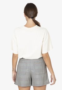 Korte mouwen, crèmekleurig katoenen T-shirt gecombineerd met hooggesneden, grijs geruite shorts met zakken en een getailleerde snit.