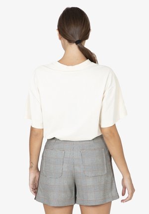 Korte mouwen, crèmekleurig katoenen T-shirt gecombineerd met hooggesneden, grijs geruite shorts met zakken en een getailleerde snit.