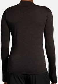 Camicia a maniche lunghe in tessuto grigio scuro, con scollatura rotonda e design aderente. La texture è liscia con una leggera elasticità. Semplice e funzionale.