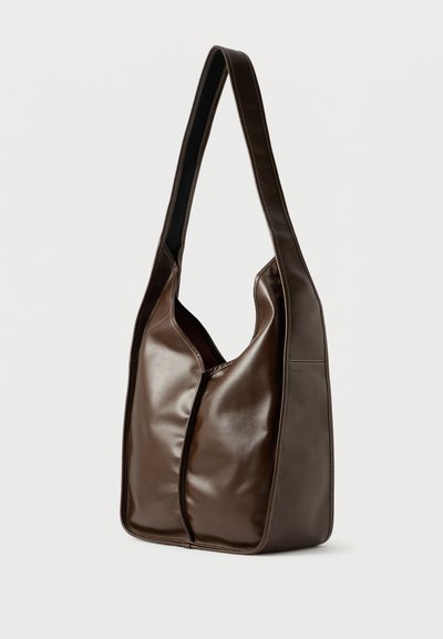 Barna bőr válltáska sima textúrával, ívelt formával és egy hosszú pánttal; középső cipzáras záródással és tiszta varrási részletekkel rendelkezik.