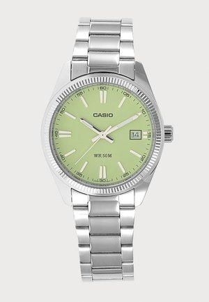 Srebrni Casio ručni sat s okruglim svijetlozelenim brojčanikom, bijelim oznakama sati, prikazom datuma i metalnom narukvicom s poveznicama.