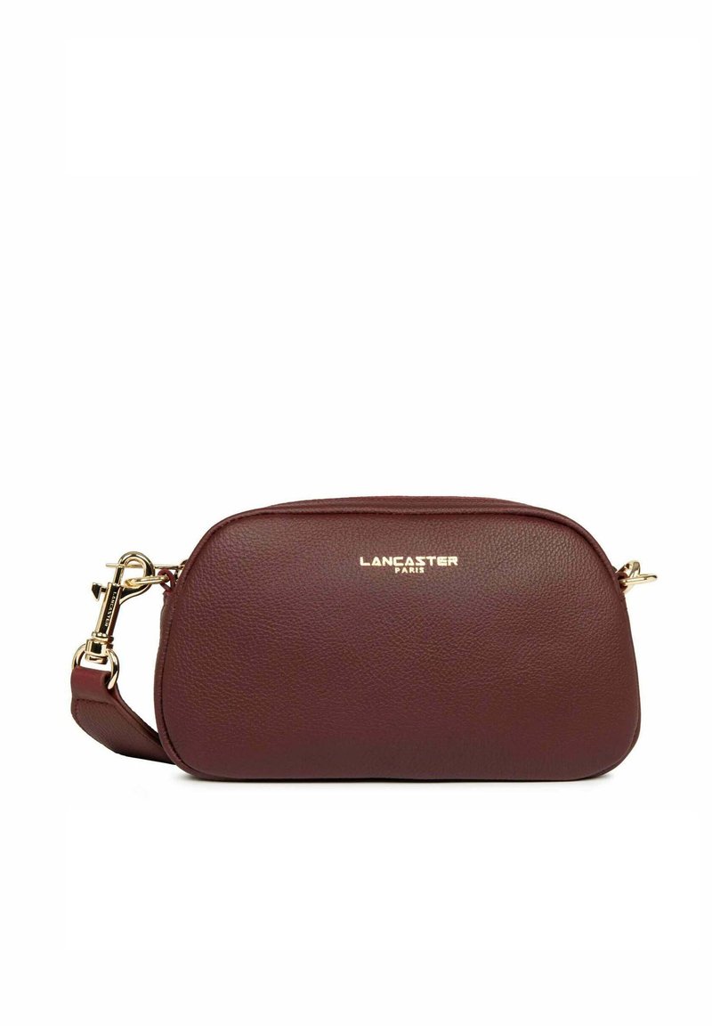 Borsa a tracolla in pelle marrone con un design arrotondato, hardware dorato e chiusura con zip; presenta una tracolla removibile e una stampa del logo.