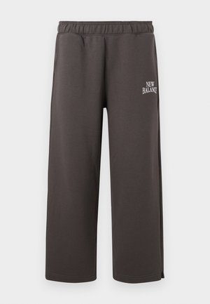 Pantalon de survêtement gris foncé à jambes droites avec taille élastique et petit logo blanc « New Balance » sur la cuisse droite.