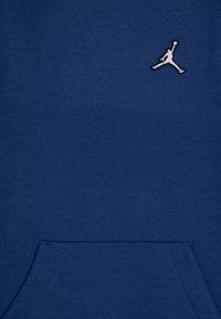 Felpa blu navy in misto cotone, con tasca frontale e logo Jumpman cucito in bianco sulla parte superiore sinistra del petto.