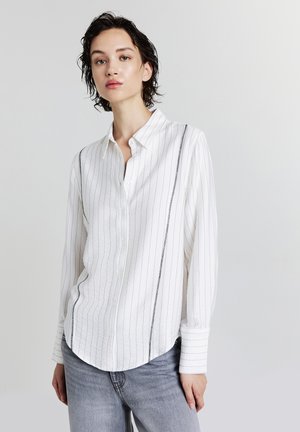 White button-up shirt with vertical black stripes, long sleeves, and a rounded hem. Made of lightweight fabric with a soft texture.