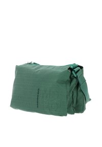 Sac d'épaule en tissu vert avec une surface texturée, fermeture à glissière et bandoulière réglable. Forme rectangulaire compacte aux bords doux.