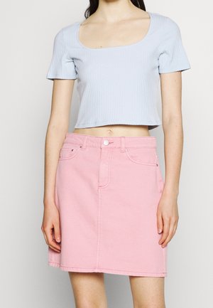 Lyseblå ribbet croptop med korte ærmer kombineret med en lyserød denimnederdel med diskrete syninger og klassisk fem-lomme-design.