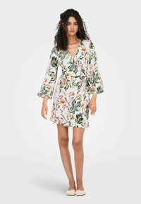 Blumenwickelkleid aus leichtem Stoff mit grünen Blättern und rosa Blumen. V-Ausschnitt, lange Ärmel und mit einem Taillengürtel; knielang.