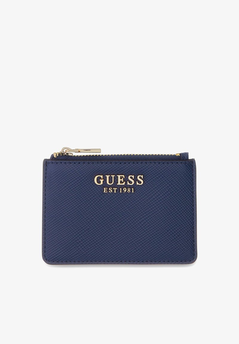 Portefeuille bleu marine texturé avec logo doré "GUESS EST 1981" et fermeture éclair dorée sur le dessus, sur fond blanc.
