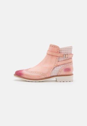 Bottine en cuir rose avec un talon texturé à motif blanc, détails brogue, boucle en métal, et un embout légèrement arrondi.