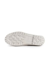 Semelle de chaussure, matériau en caoutchouc texturé, principalement blanche avec un design de grip à motifs présentant différentes formes et éléments surélevés.