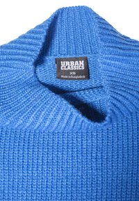 Pulover albastru din tricot cu dungi, cu guler pliat, care arată o etichetă neagră cu inscripția "URBAN CLASSICS XS Fabricat în Bangladesh."