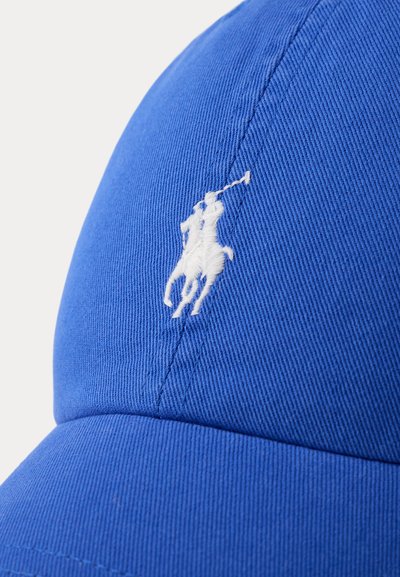 Casquette en tissu bleu avec logo blanc brodé représentant une personne à cheval tenant un maillet de polo sur le panneau avant.