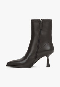 Bottine en cuir noir avec bout pointu, fermeture éclair latérale, et talon évasé élancé de hauteur moyenne, sur fond blanc.
