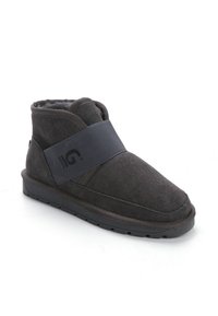 Botas de tobillo gris oscuro, hechas de ante, con una amplia banda elástica en la parte delantera con logo, forro suave y suela plana de goma.