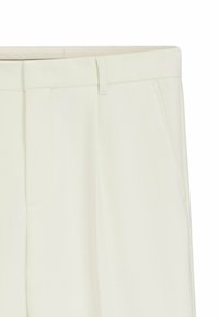 Witte op maat gemaakte broek met een gladde textuur, voorzakken en een platte voorkant voor een strakke uitstraling.