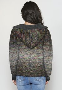 Multikleurige gebreide hoodie met een donkergrijze fleece-voering in de capuchon, ribgebreide manchetten en een gradientpatroon dat overgaat van levendige naar donkere tinten.