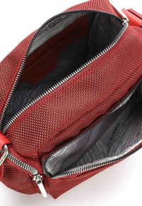 Czerwona torba z plecionego materiału z srebrnymi zamkami błyskawicznymi. Wewnątrz znajduje się szara podszewka z wzorem tekstowym oraz kieszonka na drobiazgi. Kompaktowy i zorganizowany design.