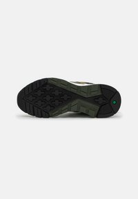 Gumowa podeszwa z głębokim bieżnikiem zapewniającym przyczepność, w kolorystyce czarno-zielonej. Wytłoczony logo "Timberland" z boku.