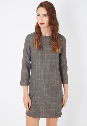 Vestido a rayas grises con mangas tres cuartos, escote cuadrado y líneas azules que atraviesan el patrón. Forma corta y estructurada.