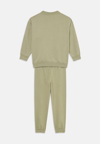 Ljusgrön matchande sweatshirt och sweatpants-set. Mjuk textur, avslappnad silhuett, ribbade muddar och midja. Enkel design utan utsmyckningar.