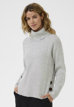 Pulover turtleneck gri deschis, realizat dintr-un material canalat, cu o croială lejeră și detalii cu nasturi maro pe părțile laterale. Textură moale și design relaxat.