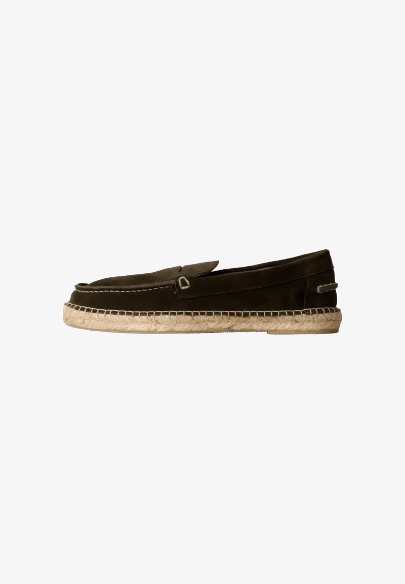 Zapatos marrones de ante tipo slip-on con suela de yute trenzada, que presentan un pequeño acento decorativo en la parte superior y una textura suave.