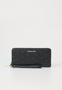 Porte-monnaie en cuir noir avec motif en relief du logo MK, quincaillerie dorée, fermeture éclair et sangle de poignet amovible. Forme rectangulaire plate.