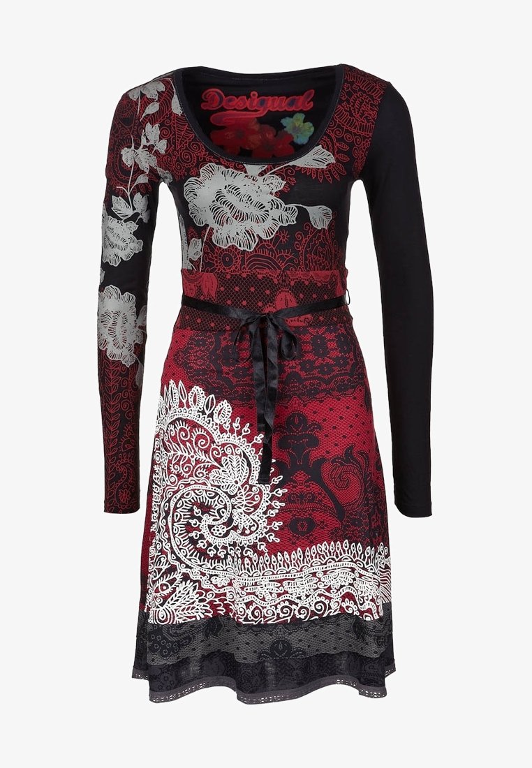 Langärmliges Kleid mit einem enganliegenden schwarzen Oberteil und einem ausgestellten roten Rock, der mit weißen und schwarzen Blumen- und Paisleymustern verziert ist. Mit gebundenem Taillenbereich.