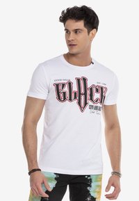 Weißes Baumwoll-T-Shirt mit fettem schwarzen und roten Grafiktext "BLHCK" auf der Vorderseite, kurzen Ärmeln und rundem Ausschnitt.