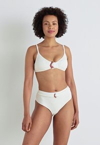 White bikini set with textured fabric; top features a front knot detail, while bottom has a high-waisted design with a matching accent.