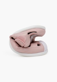 Chaussures pour bébé en cuir rose avec des découpes de ventilation et des sangles en velcro. Semelles en caoutchouc blanc arrondies et texture douce. Design compact.