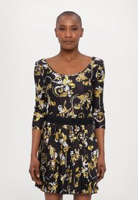 Black dress with a floral pattern in yellow and white, featuring a scoop neck, three-quarter sleeves, and a pleated skirt.