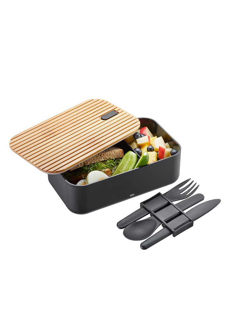 Mittagsbox mit schwarzem Boden und geriffeltem Bambusdeckel, gefüllt mit Salat, Obst und Sandwich; enthält ein schwarzes Plastikutensilien-Set mit Halter.