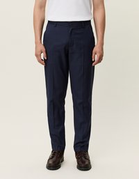 Laivastonsiniset housut, joissa on suora lahkeiden muotoilu, valmistettu sileästä kankaasta. Ominaisuuksiin kuuluu yksittäinen nappisulku ja sivutaskut. Yhdistetty tummiin kenkiin.