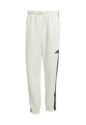 Vita sweatpants gjorda av ett mjukt material, med svarta sidostreck, elastisk midja med dragsko och åtsittande muddar vid anklarna.